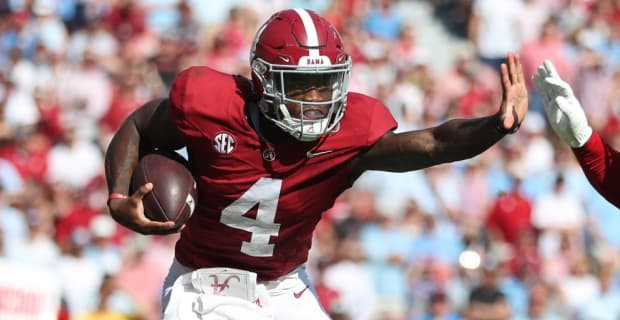 Alabama Crimson Tide quarterback Jalen Milroe on a rushing attempt during a college football game in the SEC.